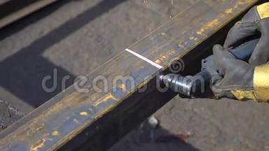 一个<strong>带手套</strong>的工作金属仓库用焊机切割金属横梁